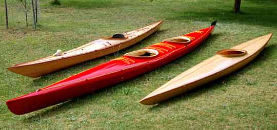 Three wooden kayaks on the lawn