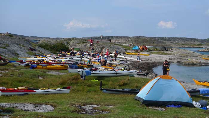 Stranden på Vallerö fylls sakta med kajaker och tält